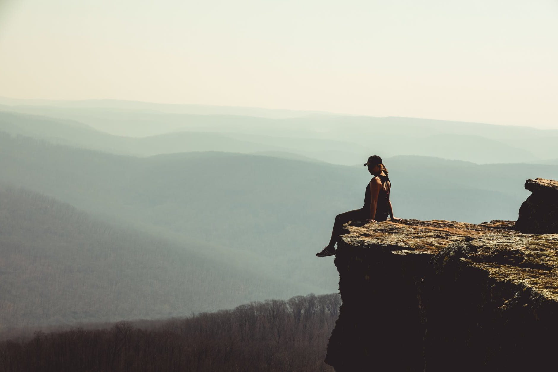 woman sitting on edge of rock formation