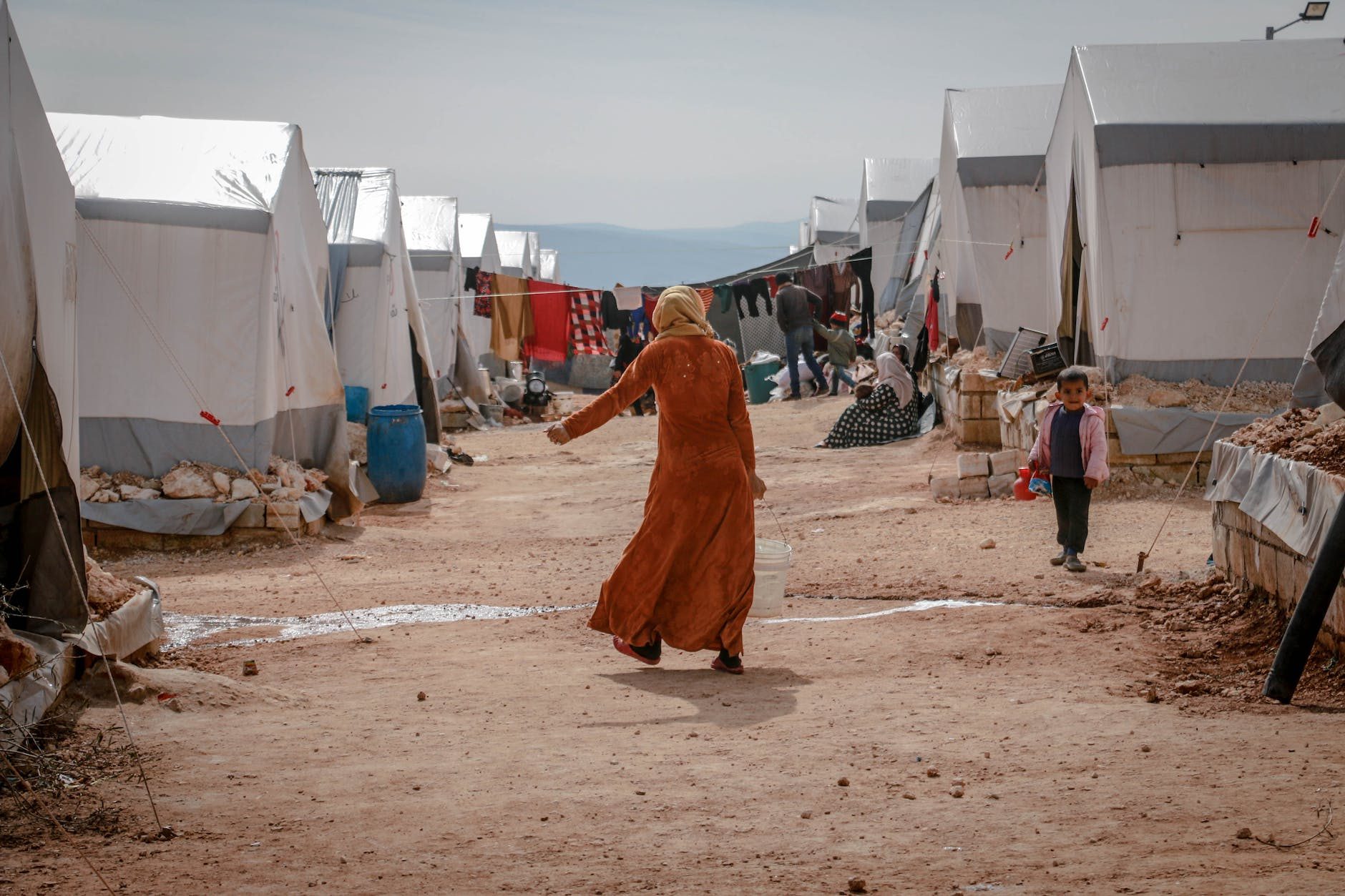 anonymous woman walking in refugee camp