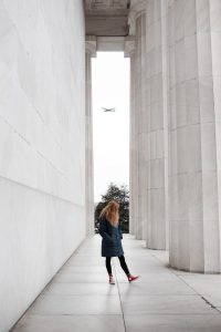 woman standing near marble pillars